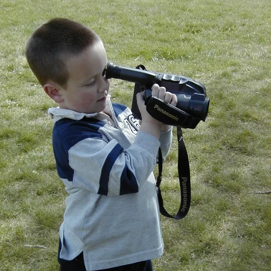 Maverick Beach as a child holding a camcorder