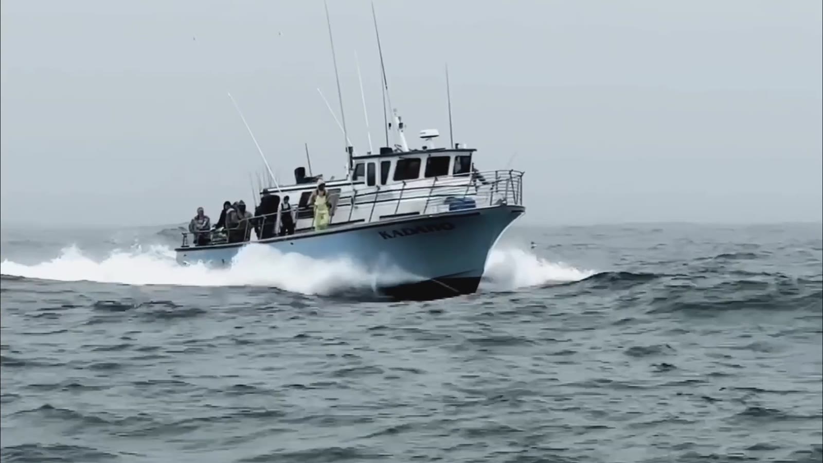 People traveling across open water on a working boat